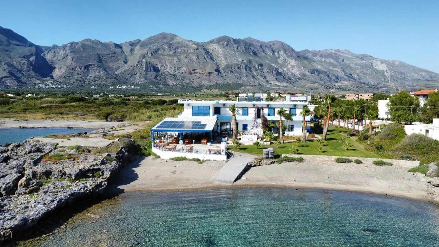 Ein kleines Hotel direkt an der Bucht, dahinter die Berge